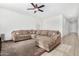 Living room with L-shaped sofa, large TV, and ceiling fan at 2091 W Garland Dr, San Tan Valley, AZ 85144