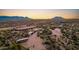 Aerial view of a sprawling desert property with a large house, stables, and riding arena at 26639 N 132Nd St, Scottsdale, AZ 85262