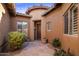 Inviting courtyard entry with flagstone pathway, potted plants, and a wooden door at 32051 N 73Rd Pl, Scottsdale, AZ 85266