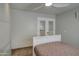 Bedroom with ceiling fan and double doors leading to an office at 8428 E Meseto Cir, Mesa, AZ 85209