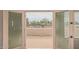 View from the back of house shows a tennis court, pool, and lush landscaping at 8611 E Cholla St, Scottsdale, AZ 85260