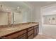 Double vanity bathroom with granite countertop and large mirror at 8611 E Cholla St, Scottsdale, AZ 85260