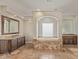 Spa-like bathroom with soaking tub, double vanity, and large mirror at 8611 E Cholla St, Scottsdale, AZ 85260