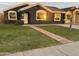 Charming single-story home with a dark blue exterior, lush green lawn, and a welcoming walkway at 977 S Matilda St, Florence, AZ 85132