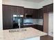 Modern kitchen with dark cabinets, granite counters and stainless steel appliances at 21024 E Poco Calle St, Queen Creek, AZ 85142