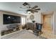 Relaxing living room featuring a large TV, comfy seating, and ceiling fan at 3444 E Melody Dr, Phoenix, AZ 85042