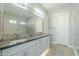 Modern bathroom with dual vanities, a large mirror, and gray cabinets at 36073 N Stoneware Dr, Queen Creek, AZ 85140