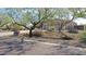 Landscaped front yard with mature trees and a three-car garage at 3701 E Sat Nam Way, Cave Creek, AZ 85331