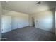 Spacious bedroom with neutral colored carpet and doors to another room at 38113 N Stallion St, San Tan Valley, AZ 85140