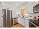 Modern kitchen with white cabinets, stainless steel appliances, and quartz countertops at 7446 N 44Th Dr, Glendale, AZ 85301