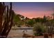 Desert landscaping and luxury home with mountain views at sunset at 10542 E Skinner Dr, Scottsdale, AZ 85262