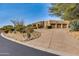 Desert landscape surrounds this three-car garage home with stucco exterior at 10542 E Skinner Dr, Scottsdale, AZ 85262