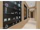 Hallway with glass-shelved display cases and artwork at 10542 E Skinner Dr, Scottsdale, AZ 85262