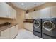 Laundry room with modern washer, dryer, and granite countertops at 10542 E Skinner Dr, Scottsdale, AZ 85262