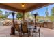 Outdoor dining area on patio with seating, heaters, and pool views at 10542 E Skinner Dr, Scottsdale, AZ 85262