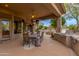 Covered patio with seating area, built-in grill, and views of the backyard at 10542 E Skinner Dr, Scottsdale, AZ 85262