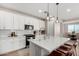 Modern kitchen with white cabinets, a large island, and pendant lighting at 11980 S 173Rd Ave, Goodyear, AZ 85338