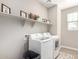 Bright laundry room features washer, dryer, and ample shelving at 11980 S 173Rd Ave, Goodyear, AZ 85338