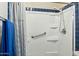 Bathroom with shower, grab bar, and blue tile details at 14444 W Moccasin Trl, Surprise, AZ 85374