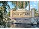 Sun Village community entrance with a scenic pond and lush landscaping at 14444 W Moccasin Trl, Surprise, AZ 85374