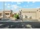 Tan stucco house with a two-car garage and landscaped front yard at 14444 W Moccasin Trl, Surprise, AZ 85374