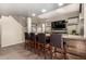 Modern kitchen island with four leather barstools, granite countertop, and wood accents at 18242 N 170Th Ln, Surprise, AZ 85374