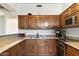 L-shaped kitchen with granite countertops and wood cabinets at 24218 N 85Th St, Scottsdale, AZ 85255