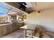 Outdoor kitchen with built-in grill, stone countertops, and wooden seating at 24218 N 85Th St, Scottsdale, AZ 85255