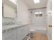 Updated bathroom features a marble countertop vanity, shower, and soaking tub at 4620 E Montecito Ave, Phoenix, AZ 85018