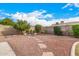 Landscaped backyard with gravel, trees, and a stone water feature at 5445 E Farmdale Ave, Mesa, AZ 85206