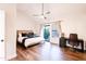 Spacious bedroom with vaulted ceiling, wood floors, and access to balcony at 7272 E Gainey Ranch Rd # 75, Scottsdale, AZ 85258