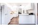 Modern kitchen featuring white cabinetry, a breakfast bar, and hardwood floors at 7272 E Gainey Ranch Rd # 75, Scottsdale, AZ 85258