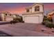 A charming two-story home at sunset with an attached garage, a paved driveway, and desert landscaping at 18637 N 35Th St, Phoenix, AZ 85050