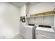 Bright laundry room complete with washer, dryer, and shelving at 22520 E Rosa Rd, Queen Creek, AZ 85142