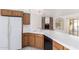 Open kitchen with white tile counters, wood cabinets, and a view to the backyard at 418 W Bentrup St, Chandler, AZ 85225