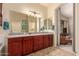 Double vanity bathroom with granite countertop and access to bedroom at 4312 N Verrado Way, Buckeye, AZ 85396