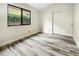 Bright bedroom with wood-look tile flooring and a large window at 5016 E Marconi Ave, Scottsdale, AZ 85254