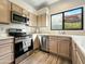Well-equipped kitchen featuring stainless steel appliances and light wood cabinets at 5016 E Marconi Ave, Scottsdale, AZ 85254