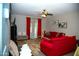 Living room with red couches, coffee table and ceiling fan at 8426 W Atlantis Way, Tolleson, AZ 85353