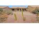 Back exterior view of house with covered patio and desert landscaping at 9209 E Emerald Dr, Sun Lakes, AZ 85248