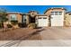 Tan two-story house with a three-car garage and landscaping at 17826 W Straight Arrow Ln, Surprise, AZ 85387