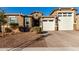 Tan two-story house with a three-car garage and landscaping at 17826 W Straight Arrow Ln, Surprise, AZ 85387