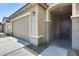 Two-car garage and entryway with a dark brown door at 21686 N 259Th Dr, Buckeye, AZ 85396