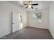 Spacious bedroom with ceiling fan and door to hallway at 32922 N Pebble Creek Dr, San Tan Valley, AZ 85143