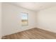 Simple bedroom with wood-look floors and a window with blinds at 35041 W Euclid Ave, Tonopah, AZ 85354