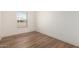 Cozy bedroom with wood-look floors and a large window at 35041 W Euclid Ave, Tonopah, AZ 85354