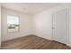 Bright bedroom with wood-look floors and a window with blinds at 35041 W Euclid Ave, Tonopah, AZ 85354