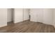 Well-lit bedroom with wood-look floors and multiple doors at 35041 W Euclid Ave, Tonopah, AZ 85354