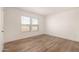 Bright bedroom with wood-look floors and two large windows at 35041 W Euclid Ave, Tonopah, AZ 85354
