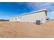 Light gray manufactured home exterior with several windows and a back patio at 35041 W Euclid Ave, Tonopah, AZ 85354